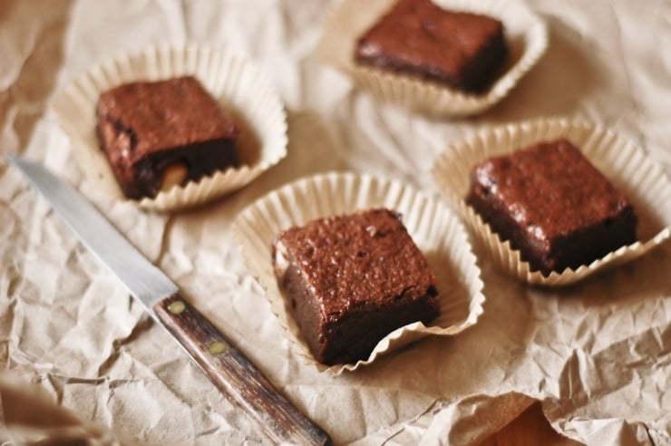 A gooey, fudgy-bellied, gluten-free brownies recipe. Each delicious, gluten-free flourless brownie is studded with shards of macadamia nuts and pistachios. | sophisticatedgourmet.com