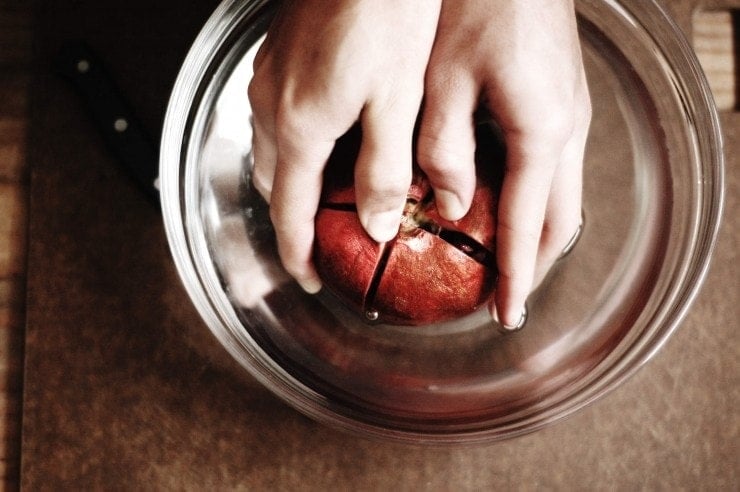Separating cut pomegranate sections in water 