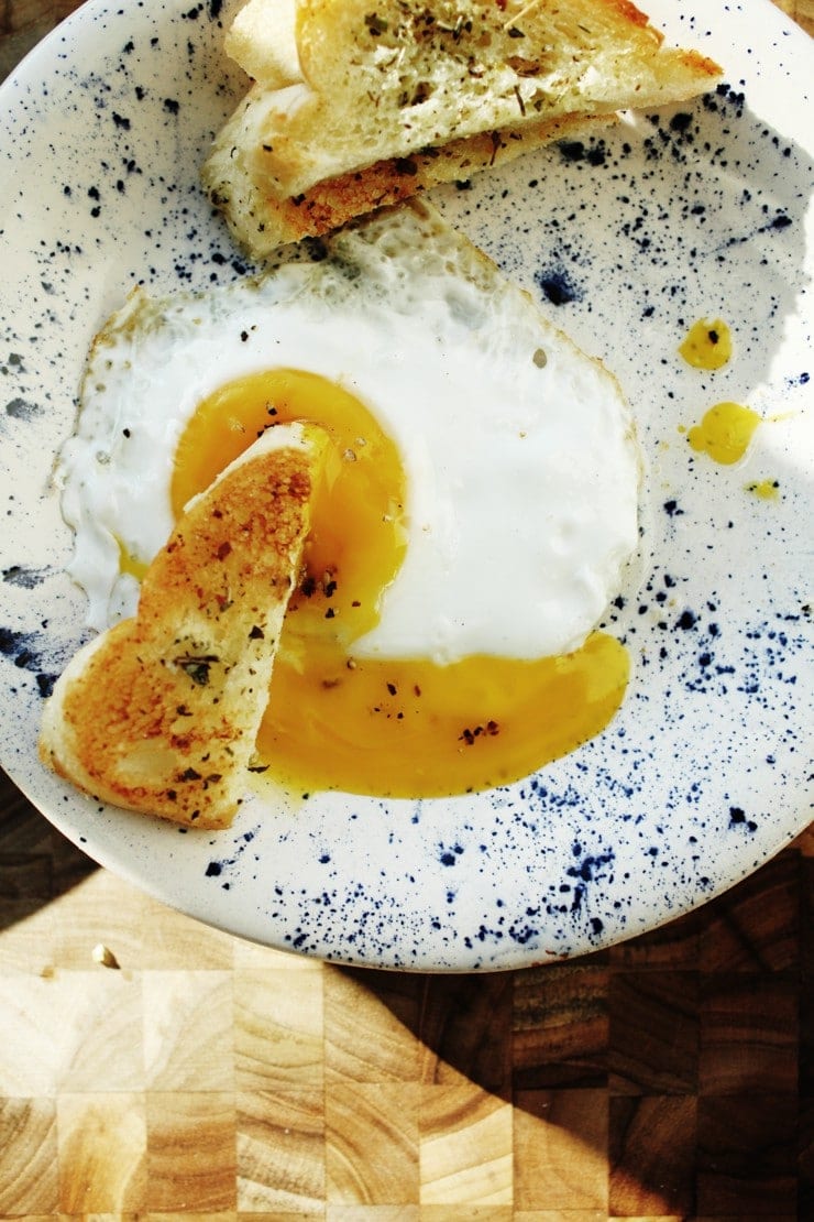 Sunny-side up runny yolk egg with herb toast