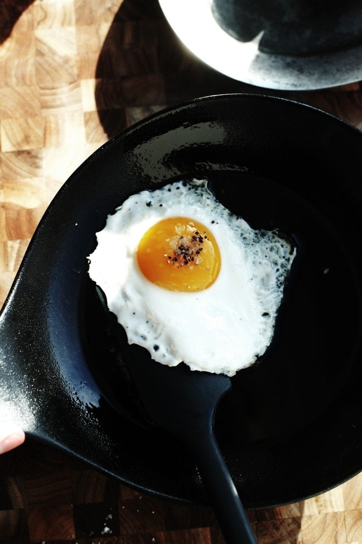 Lifting a fried egg in cast-iron skillet