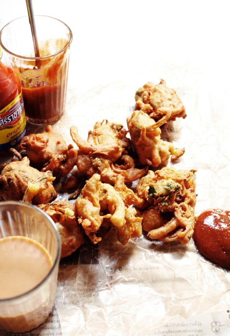 The best authentic crispy onion pakora recipe (pakoda) served with a delicious pakora sauce. Pakoras are delicious, easy, vegan, and gluten-free! | sophisticatedgourmet.com